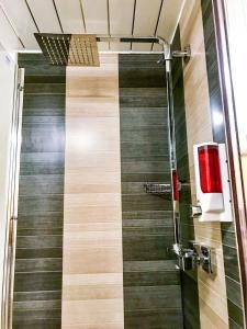 a shower stall with a red soap dispenser on the wall at Hydro Apartment with free car park in Glasgow