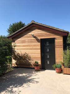 un garage con una porta nera e due piante di Coastal Retreat a Lowestoft