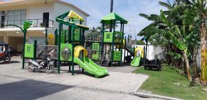 un parque infantil con juegos verdes y amarillos en Your Holiday Home( Studio, King Size Bed), en Mactan