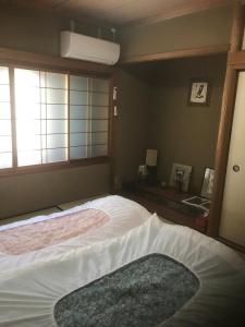 um quarto com uma cama grande e uma janela em Kyoto Guesthouse Oyado Kei em Quioto