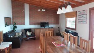 a living room with a wooden table and a tv at La Otra Vista in Valparaíso