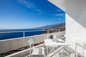 a balcony with a table and chairs and the ocean at Breathtaking 180 degrees Views in Tabaiba Alta in Santa Cruz de Tenerife