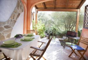 una sala da pranzo con tavolo e sedie su un patio di Li Rocchi a San Teodoro