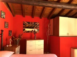 デセンツァーノ・デル・ガルダにあるDesenzanoLoft La Baitaの赤い壁のベッドルーム(ベッド1台、鏡付)