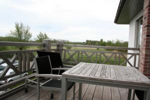 a wooden table and two chairs on a deck at Biznis Hotel in Lokeren