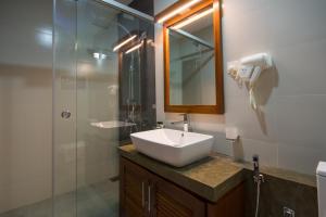 a bathroom with a sink and a mirror at Ceyloni City Hotel in Kandy