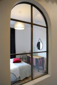 a bedroom through a window with a bed and a table at Troisième Droite in Cahors