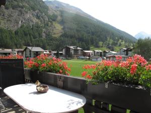 a table with a bowl on it in front of flowers at Ferienhaus Alea in Saas-Grund