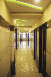 a hallway in a building with doors and tile floors at Hotel Royal Inn in Hiriyūr