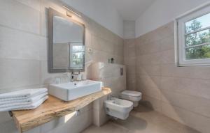 a white bathroom with a sink and a toilet at Villa Bogijeva in Rabac +16 photos
