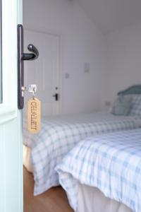 Dormitorio con cama con etiqueta en la puerta en Elm Cottage Touring Park en Whitegate