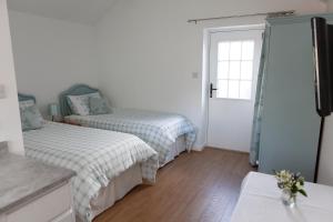 a bedroom with two beds and a window at Elm Cottage Touring Park in Whitegate