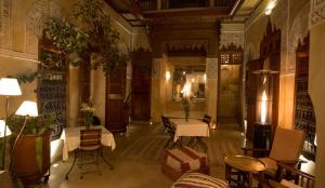 a lobby with tables and chairs in a building at Riad Dar Zaya in Marrakech