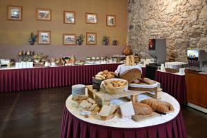 a table with various breads and baskets on it at LH Hotel Dvořák Tábor Congress & Wellness in Tábor