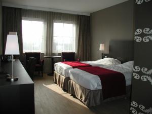 a hotel room with a bed and a window at Biznis Hotel in Lokeren