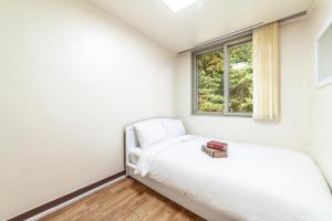 a bedroom with a bed and a window at HK Resort in Sokcho