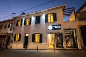 a white building with black shutters on it at Apartments Madeira City Center in Funchal
