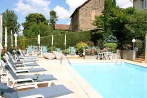 a row of lounge chairs next to a swimming pool at Logis Hôtel Auberge de L'Etang in Magnac-Bourg