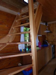 uma escada de madeira num camarote com uma cozinha em CHATA STRÁŽ em Stráž nad Nežárkou