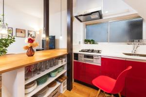 eine Küche mit roten Schränken und einem roten Stuhl in der Unterkunft Suiren Residential Suite Tokyo in Tokio