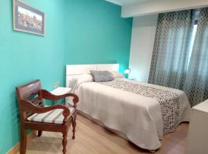 レケイティオにあるApartamento centrico en Lekeitio, playa y puertoのベッドルーム(大型ベッド1台、椅子付)