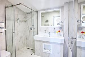 un bagno con lavandino e doccia di Hotel Central Sarajevo - Gym, Pool & Spa a Sarajevo