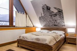 a bedroom with a bed and a large window at Apartamenty Oaza Superior Zakopane in Zakopane