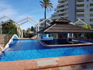a swimming pool with a gazebo next to a building at G&G Benalbeach Sea Views in Benalmádena
