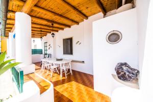 a dining room with white walls and a wooden ceiling at Casa MARINELLA in Lipari