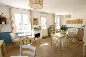 een woonkamer met tafels, stoelen en ramen bij Casa Cosy Le Pouliguen in Le Pouliguen