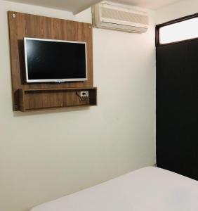 um quarto com uma televisão numa parede com uma cama em Hotel Center Plaza Plus em Cúcuta