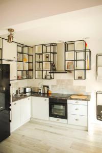 une cuisine avec des armoires blanches et des appareils noirs dans l'établissement Sunny studio on ulica Lyuben Karavelov, à Sofia