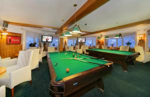 a billiard room with a pool table and chairs at Hotel Spindlerova Bouda in Špindlerův Mlýn