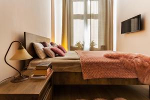 a bedroom with a bed with a lamp and a window at Apartament na Kopernika in Toruń