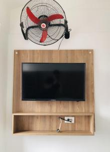 a flat screen tv with a fan on a wall at Hotel Center Plaza Plus in Cúcuta