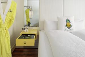 a bedroom with two twin beds and a yellow nightstand at Staypineapple, A Delightful Hotel, South End in Boston