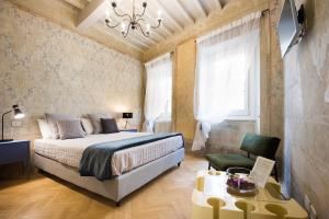 a hotel room with a bed, chair and a window at Il Piccolo Cavour Charming House B&B in Arezzo