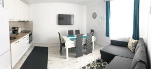 a kitchen and a living room with a table and a couch at Riverside Ski Apartment in Ramingstein