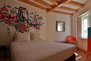 Un dormitorio con una cama con un mural en la pared. en House Petit Lusa, en Lisboa