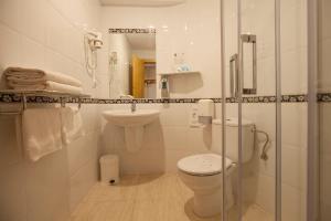 een witte badkamer met een toilet en een wastafel bij Hotel El Refugio in Cóbreces