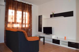 a living room with a chair and a television at Apartamentos La Eliza in Lanzahita
