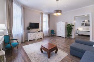 ein Wohnzimmer mit einem blauen Sofa und einem TV in der Unterkunft Hibay Apartman in Eger