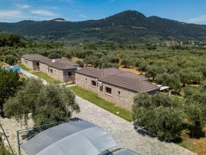 an aerial view of a house with mountains in the background at Elaionas Stone Houses in Skala Potamias +25 photos