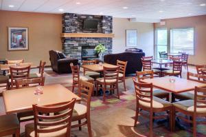 a restaurant with tables and chairs and a fireplace at Pomeroy Inn and Suites Chetwynd in Chetwynd