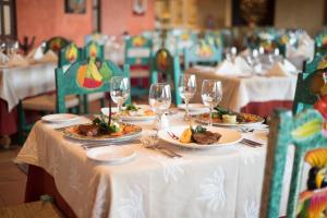 una mesa con platos de comida y copas de vino en Hacienda Tres Rios Resort Spa & Nature Park - All Inclusive, en Playa del Carmen