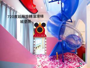 a childs play room with a water slide and balls at Fun Holiday Family Hostel in Tainan