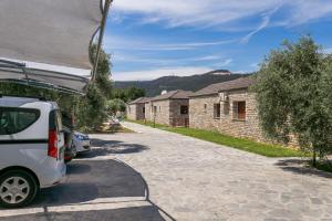 a white van parked in front of a house at Elaionas Stone Houses in Skala Potamias