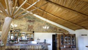 a room with a wooden ceiling and a bar at Utengule Coffee Lodge in Utengule