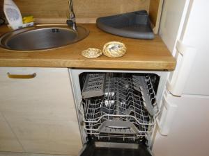 a dishwasher in a kitchen next to a sink at Oni Venus Apartament in Cluj-Napoca +19 photos
