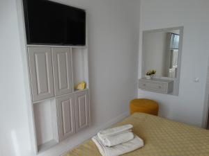 a bedroom with a table with a television on a wall at Oni Venus Apartament in Cluj-Napoca